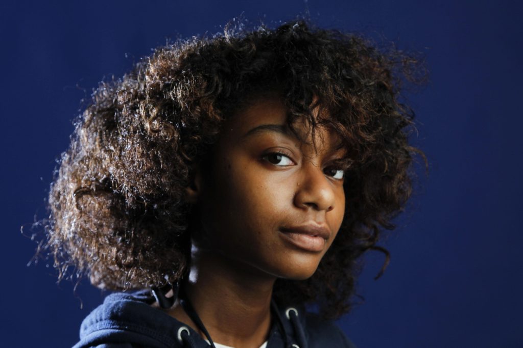 Anyssa Roberts wears her hair natural. Curly, kinky and coily natural hair is on trend, but the journey from relaxed to unprocessed can be long and frustrating. (Mark Cornelison/Lexington Herald-Leader/M