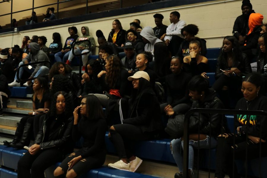 Gold squad cheerleaders, survivors and supporters sit in solidarity during the Women and Men basketball games.