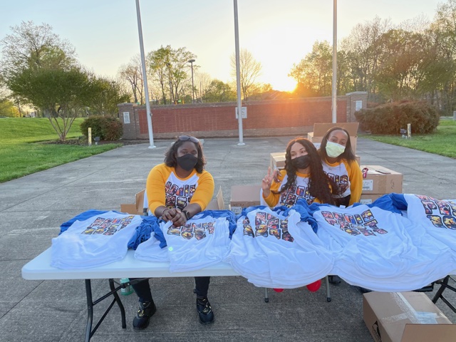 Three N.C. A&T OSA students are passing out  free Aggiefest T-shirts