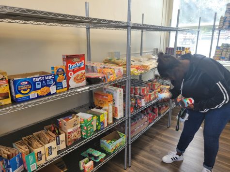 girl bending down grabbing some food items in the aggie pantry