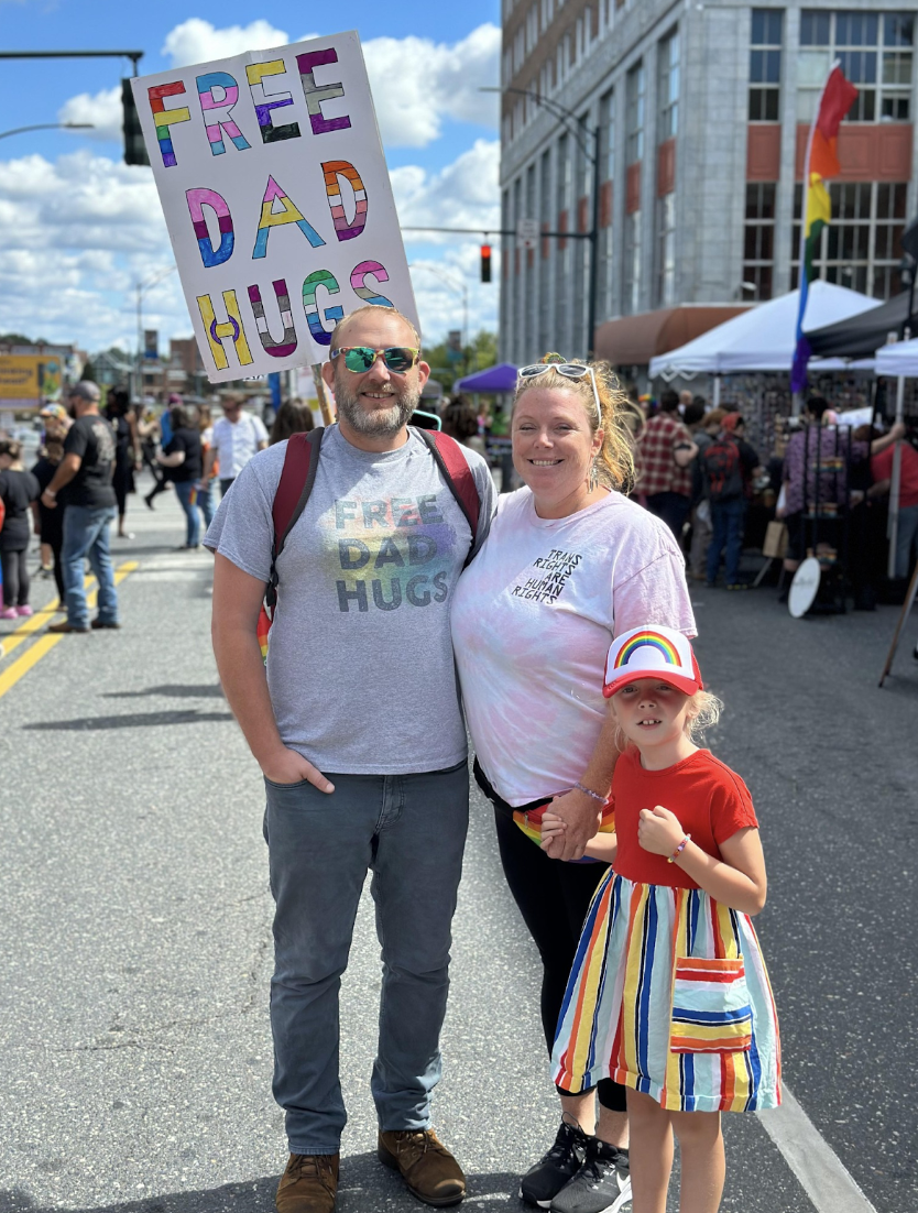 Local family attends festival with “Free Dad Hugs” sign
