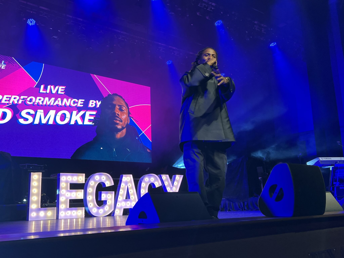 D. Smoke performing on stage at The Legacy League game show.