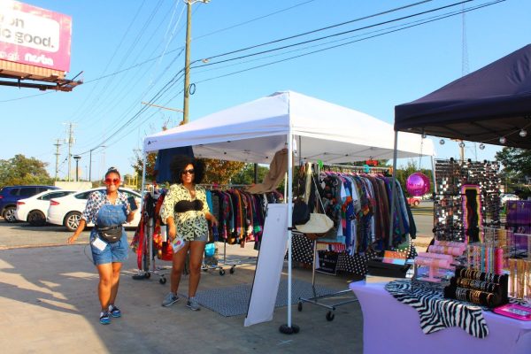 Toni Cantini and Shana Simpson, founders of Thrifty Fitz next to a stand. 