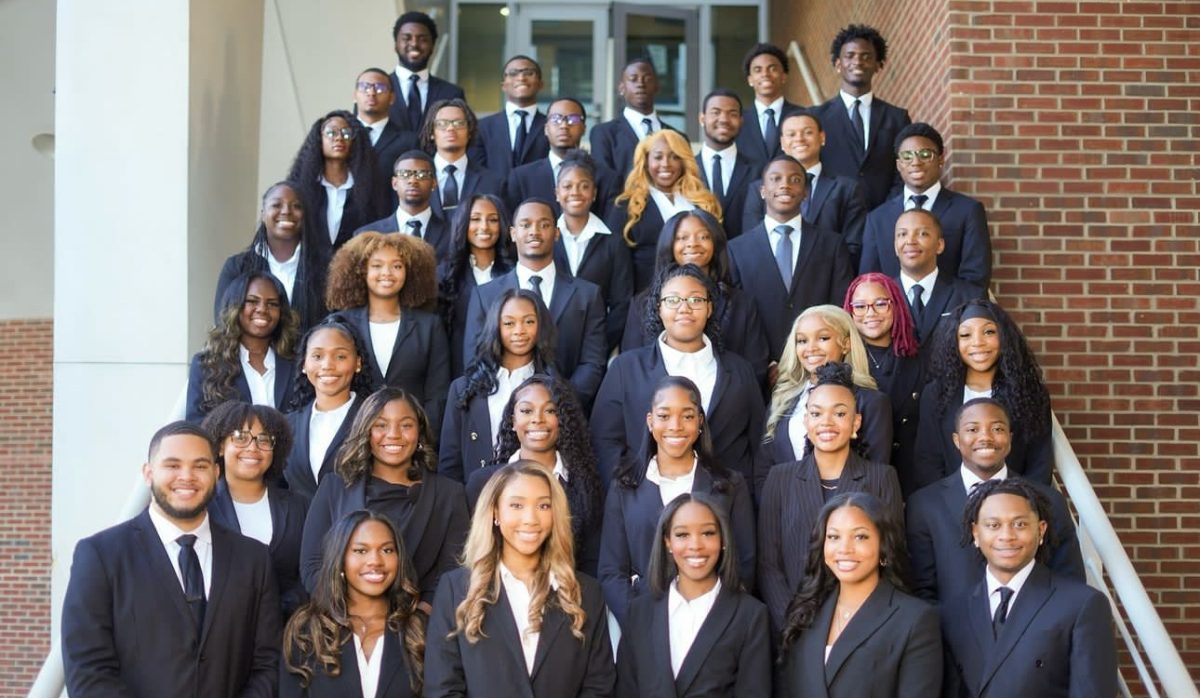 Chayse George, Jimesha Barnes (center), and the Alpha Class of The Chi Alpha Chapter of Alpha Kappa Psi.
