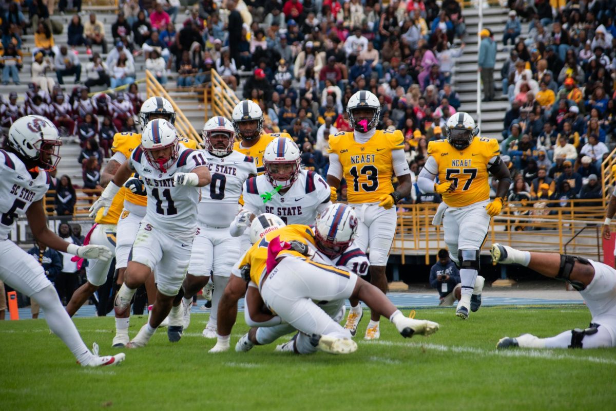 A horde of SC State Bulldogs tackle an Aggie