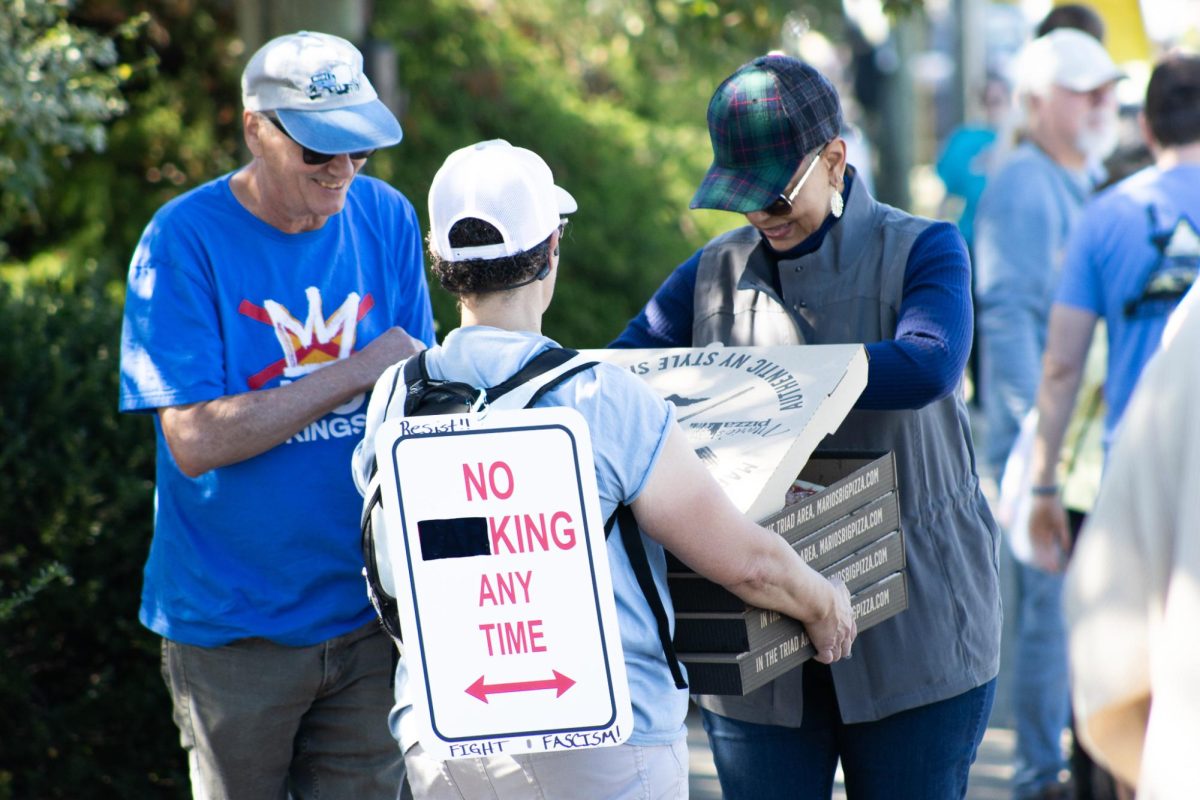 A protester hands out pizzas at the No Kings Protest on Wendover Ave.