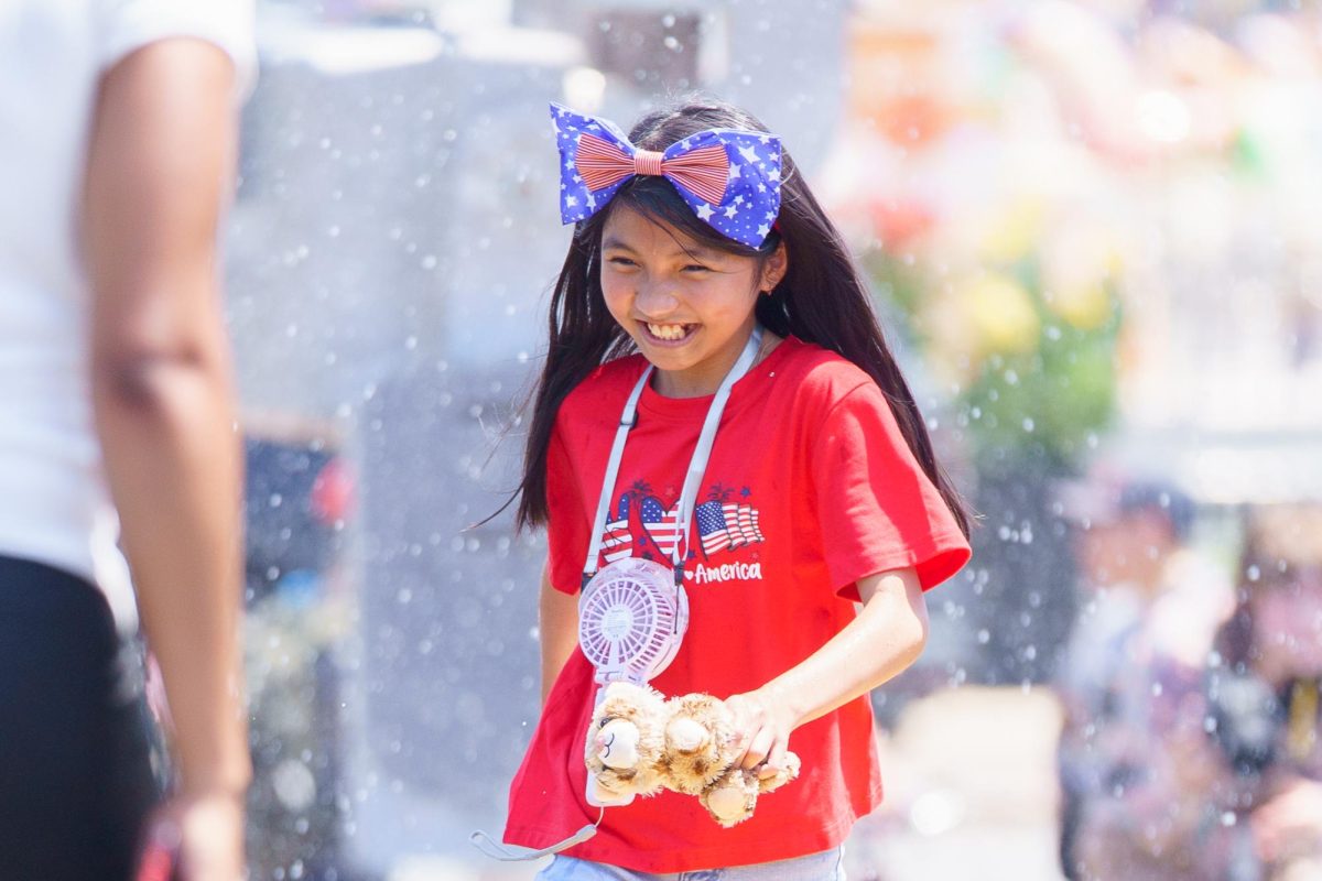 A kid enjoys the water from a fire truck during the 2026 Fun Fourth Fest.